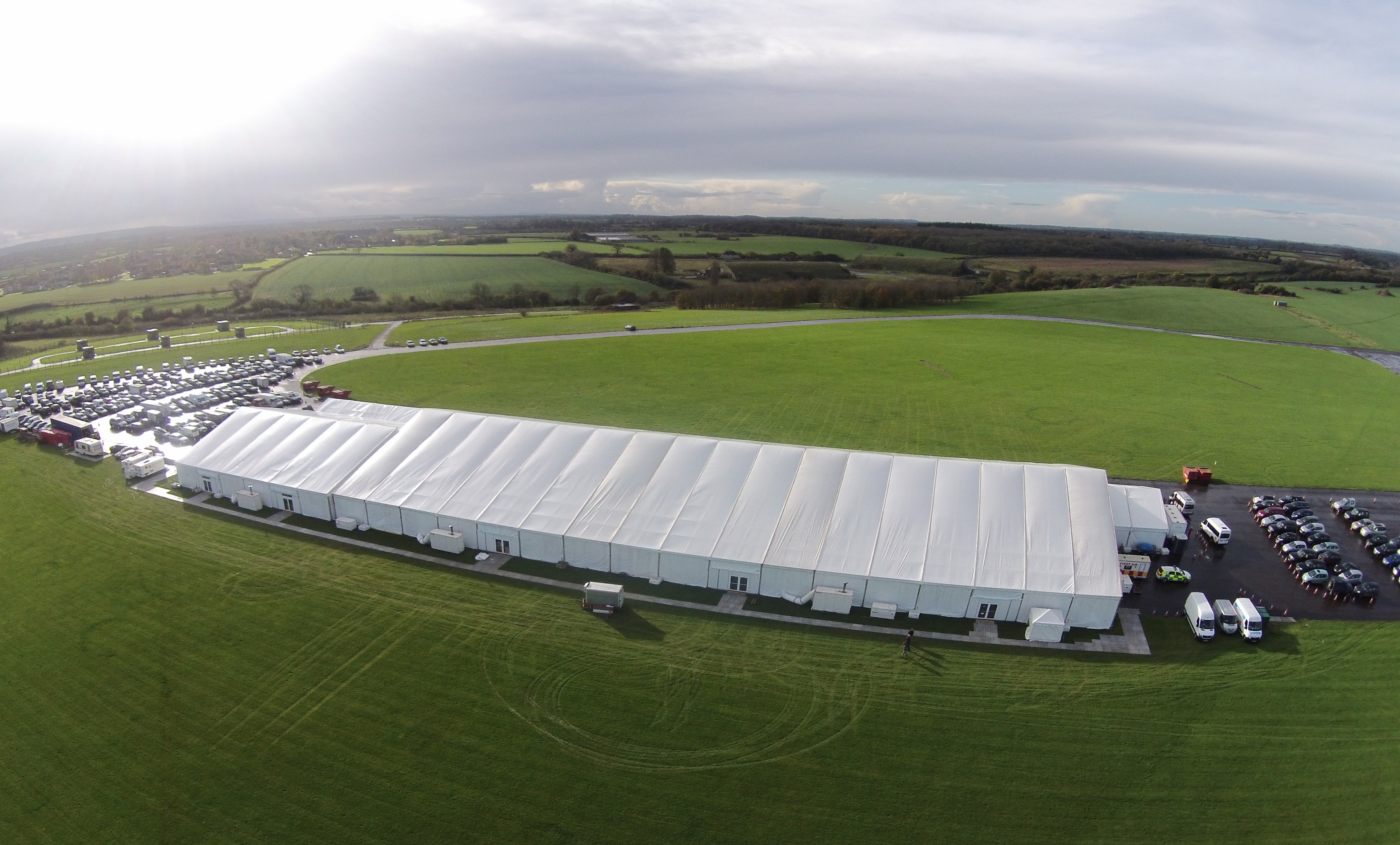 A huge white marquee in a field surrounded by cars at the Mary Howard Xmas Fair.